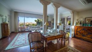 a dining room with a table and chairs and a living room at Cigarral de la Encarnación in Toledo