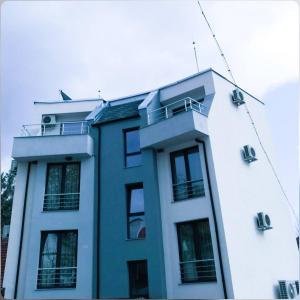 een blauw-wit gebouw met ramen erop bij Хотел ПЕРЛА in Strelcha