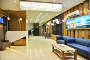 a lobby with a blue couch and a large screen at Hotel Oscar in Amritsar