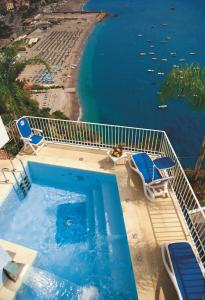 a swimming pool with chairs and a beach at Hotel Voce del Mare in Vietri sul Mare