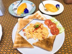 a plate of food with rice and toast and fruit at Green Home in Khao Lak