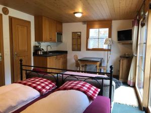 2 Betten in einem kleinen Zimmer mit Küche in der Unterkunft Sam & Cindy Mühlemann in Interlaken