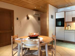 a kitchen and dining room with a wooden table and chairs at Les Berges de l'Ohmbach in Soultzmatt