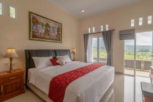 a bedroom with a large bed and a large window at Adhi Jaya Suite in Jatiluwih