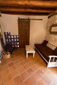 salon z kanapą i kamienną ścianą w obiekcie Casilla Fuentes w mieście Fuentes de Cuéllar