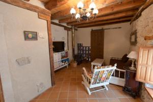 a living room with wooden ceilings and a television at Casilla Fuentes in Fuentes de Cuéllar