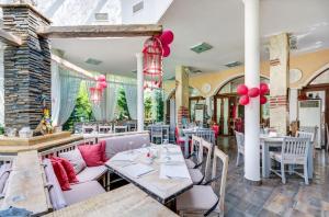 un restaurante con mesas, sillas y globos rojos en Esteban VIP Residence Club en Nesebar