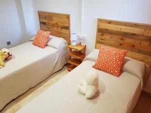 a bedroom with two beds with stuffed animals on them at Les Mercès in Deltebre