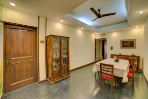 Cp Villa - Rooms with Patio في نيودلهي: غرفة طعام مع طاولة وكراسي ومروحة سقف