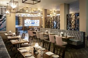 a restaurant with tables and chairs and a bar at Mercure Bridgwater in Bridgwater