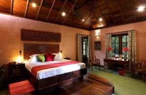 una camera da letto con un letto grande e una scrivania di Ameya Kerala a Alleppey