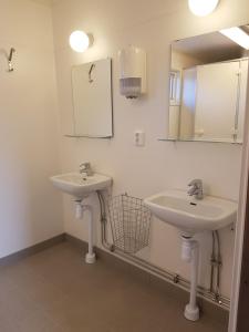 a bathroom with two sinks and a mirror at Måvikens Camping in Måviken