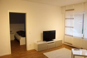een woonkamer met een televisie en een bed bij Ludwig 6 in Oberhausen