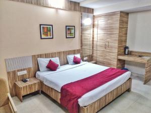 a bedroom with a large bed with red pillows at Hotel Kaveri in Allahābād +26 photos