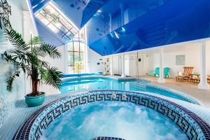 a large swimming pool with a blue ceiling at Berehayes Farmhouse in Bridport