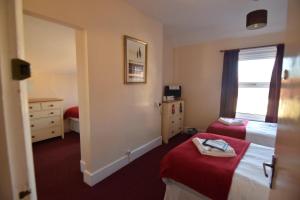 a hotel room with two beds and a mirror at Eastbourne Reymar in Eastbourne