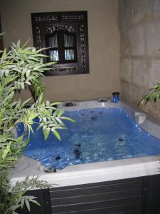 e bagno con vasca e acqua blu. di Jim cosy & spa a Saint-Hilaire-dʼOzilhan