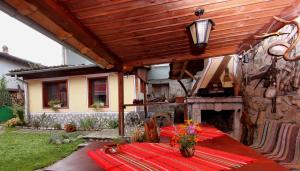 a patio with a table and a stone fireplace at Nenchova Guest House in Koprivshtitsa