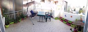 a balcony with a table and chairs and plants at MyHome! Modern, huge, central, quiet, clean in Athens