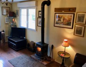 a living room with a wood stove in the corner at Dupres House, Chavasse Farm, Somme Battlefields in Hardecourt-aux-Bois