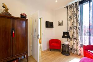 een woonkamer met een rode stoel en een raam bij Luxurious Pink House and Parking in Porto