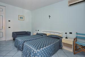 um quarto com 2 camas, uma cadeira e uma mesa em Maison Raphael em Minori
