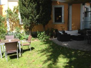 a yard with chairs and a table and a couch at Gasthof-Pension Weisz-Artner in Frauenkirchen