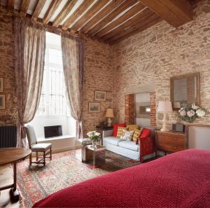 a living room with a couch and a brick wall at Le Domaine de Fleury - Pierres d'Histoire in Fleury-en-Bière
