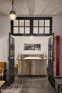 a bathroom with a tub in a room with windows at Logement De Oude Kazerne in Kaatsheuvel