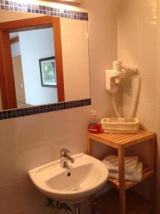 ein Bad mit einem Waschbecken und einem Spiegel in der Unterkunft Gasthof-Pension Weisz-Artner in Frauenkirchen