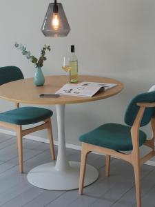 a wooden table with two chairs and a wine glass at Backsteinhaus Hanau in Hanau am Main +13 photos
