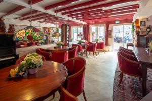 Un restaurante con mesas y sillas en una habitación. en Amsterdam House Hotel, en Ámsterdam