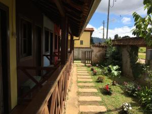 een stenen loopbrug naast een huis met bloemen bij Pousada Sossego in Lavras Novas