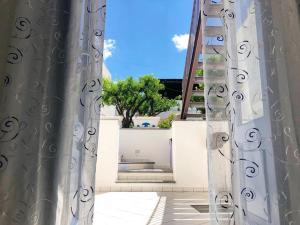 a view through the curtains of a balcony with a tree at Punta Sallustro Lipari in Lipari