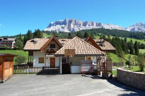 a house with a fence and mountains in the background at Chalet alla Cascata in Badia