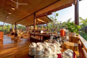 a restaurant with white mugs on a table at Phu Quoc Bambusa Resort in Phu Quoc