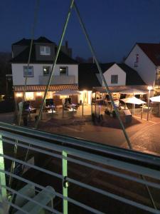 a view of a building with a parking lot at night at Heeren's Hotel Garni in Bensersiel