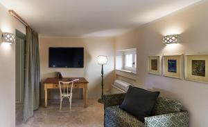 salon ze stołem, kanapą i telewizorem w obiekcie The Nest in Maremma Tuscany w mieście Montemerano