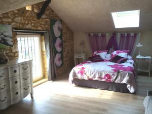 a bedroom with a bed and a dresser and a window at Le Moulin de Mayence in Plazac