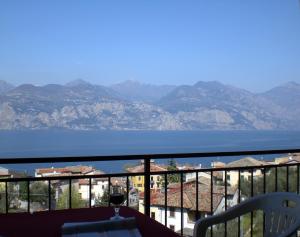 a balcony with a view of the water and mountains at New Piccolo Residence in Malcesine