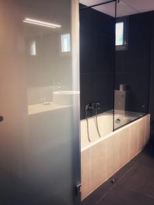 a bathroom with a bath tub and a sink at Leonidaion Guesthouse in Olympia