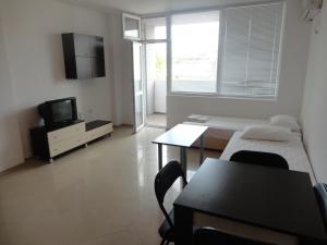 プリモルスコにあるStefani Apartmentsのベッド、テーブル、テレビが備わる客室です。