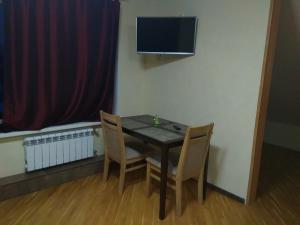 a dining room table with two chairs and a television at Room in the Country House in Minsk