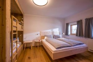 a bedroom with a large bed and a desk at Drittlhof in Hopfgarten im Brixental