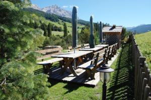 a wooden deck with a picnic table and a street light at Chalet alla Cascata in Badia +128 photos