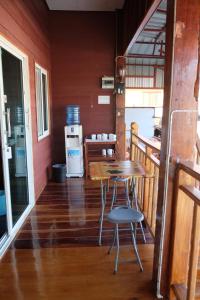 a table and chairs on a porch with a refrigerator at Baan Kokaew Chiang Khan in Chiang Khan