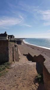 einen Sandstrand mit einem Haus und dem Meer in der Unterkunft Appartement Wimereux in Wimereux