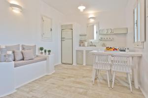 a white kitchen with a table and two chairs at Lux View Villas in Kyra Panagia