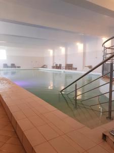 a swimming pool with a staircase in a building at Hotel Domogled in Băile Herculane