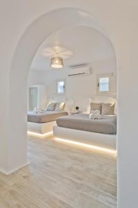 two beds in a bedroom with an archway at Lux View Villas in Kyra Panagia